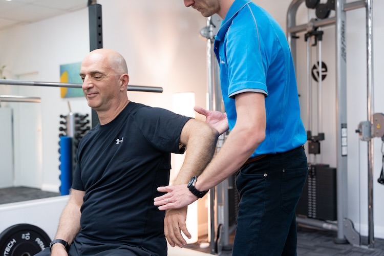 Man receiving manipulative physiotherapy during a postoperative shoulder physio appointment