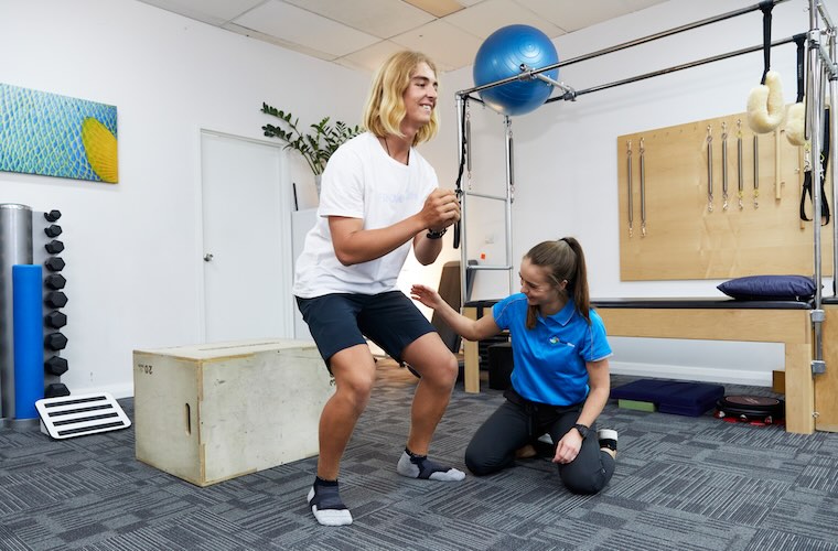 Man doing a squat during a running physio appointment