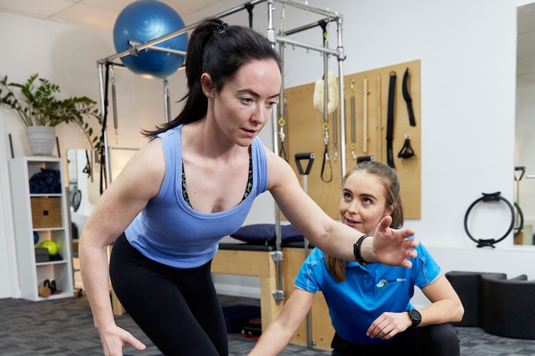 Amy supervising a single leg squat for a womens resistance training program client